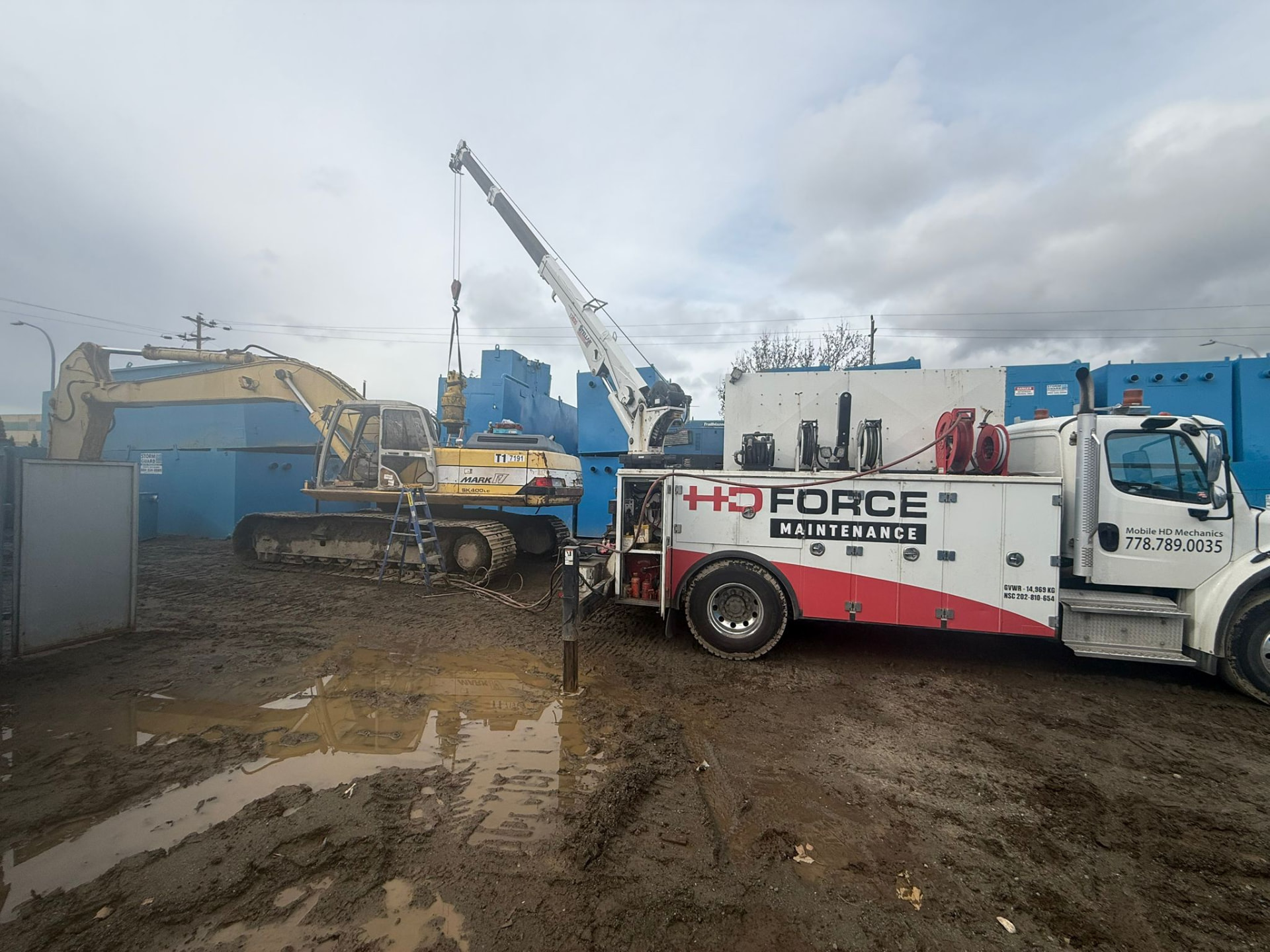 Mobile crane supporting an excavator repair