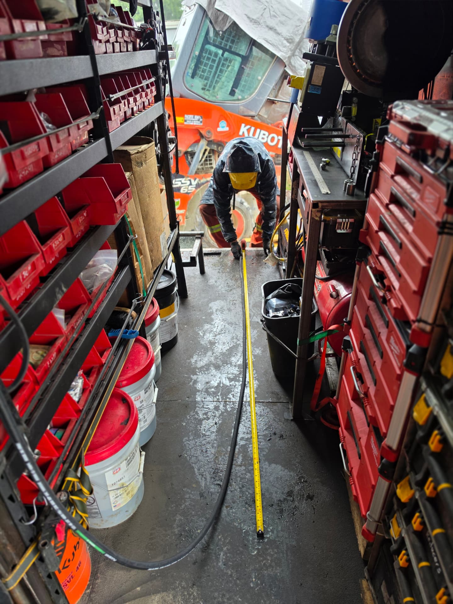 Mechanic measuring a hydraulic hose on the van floor