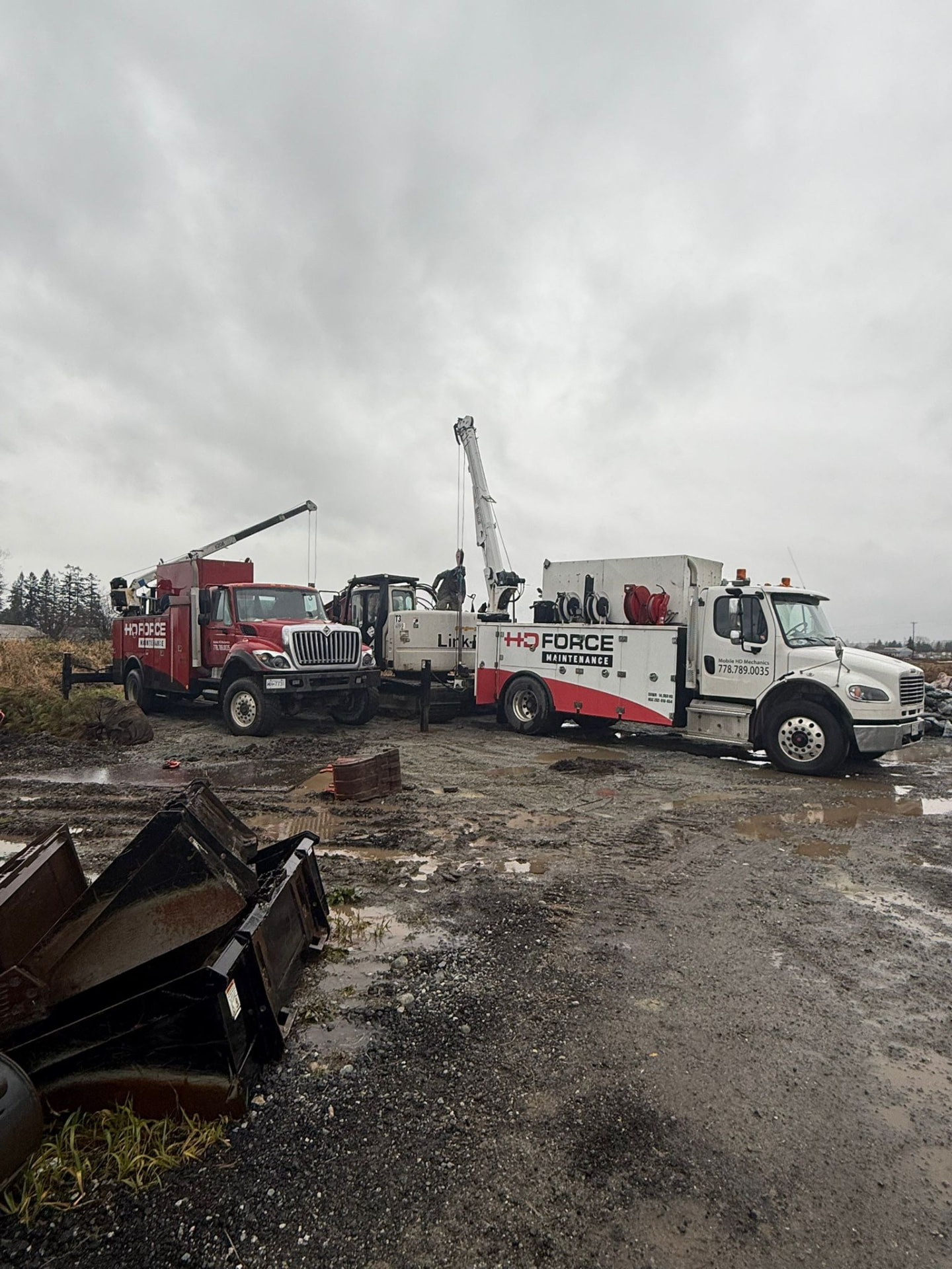 Two HD Force Maintenance service trucks parked together at a job site